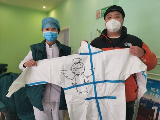 河南战“疫”暖镜头丨大学生志愿者在防护服上绘“天使”