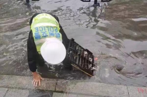 手捞杂物疏通积水、光脚提鞋行走 今早暴雨中的郑州交警是这样的